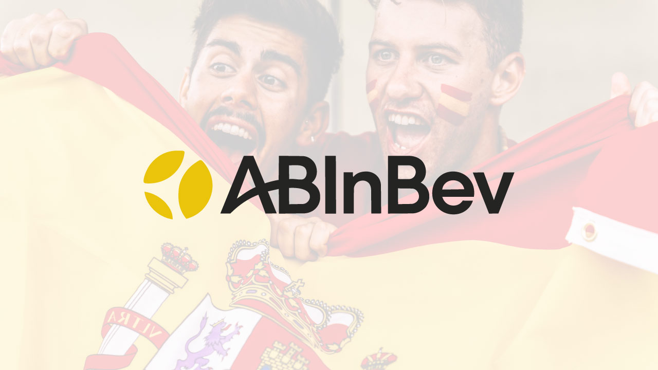 Logo de AB InBev con aficionados celebrando con la bandera de España de fondo